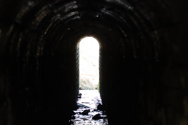 istock View through an arched tunnel carrying a stream beneath a bridge 1987636832
