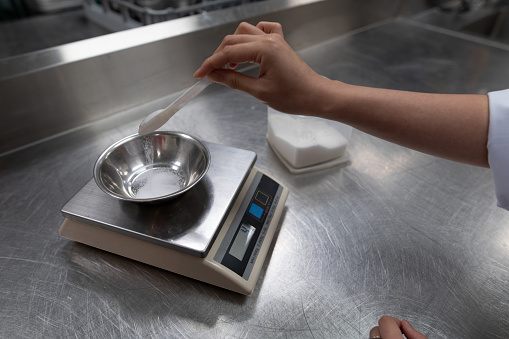 Chef using kitchen scale measure cooking ingredients before start