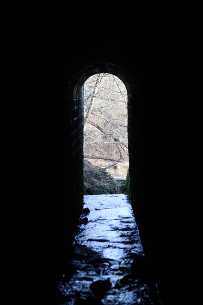 istock View through an arched tunnel carrying a stream beneath a bridge 1987640112