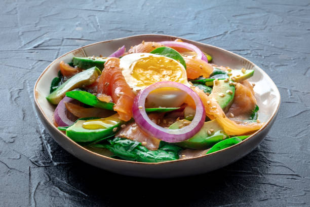 istock Salmon, avocado and egg salad with fresh leaves and onions 1987649675