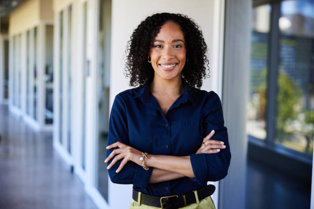 istock Young businesswoman smiling while standing in a bright office hallway 1987652288