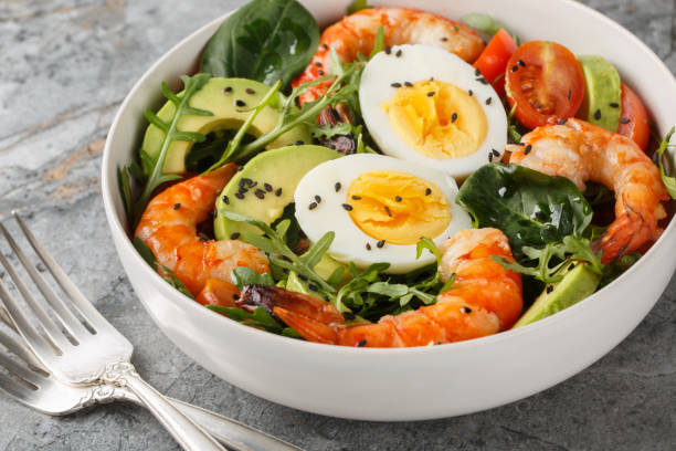 istock Balanced breakfast salad with shrimp, avocado, arugula, spinach, tomatoes and boiled eggs close-up on a bowl. Horizontal 1987654496