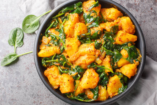 istock Saag Aloo Indian style spinach and potatoes curry in a bowl closeup. Horizontal top view 1987655135