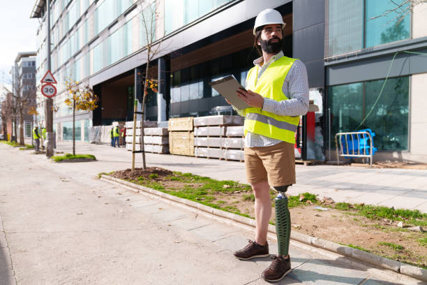 istock Focused Engineer with Prosthetic Limb Inspecting Urban Building Site 1987658419