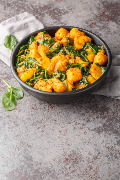 istock Aloo Palak sabzi Spinach Potatoes curry served in a bowl closeup. Vertical 1987659470