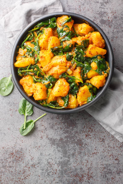 istock Aloo Palak sabzi Spinach Potatoes curry served in a bowl closeup. Vertical top view 1987659574