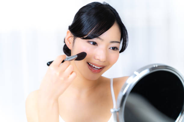 istock young Japanese woman applying makeup 1987663743