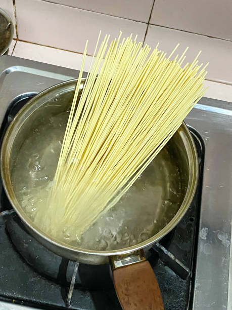 istock Someone is boiling spaghetti in boiling water using a pan. Cooking instant pasta in the kitchen. 1987694048