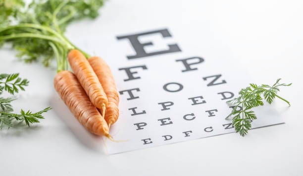 istock Fresh carrots as a source of vitamin A placed on the eye test chart. 1987695111