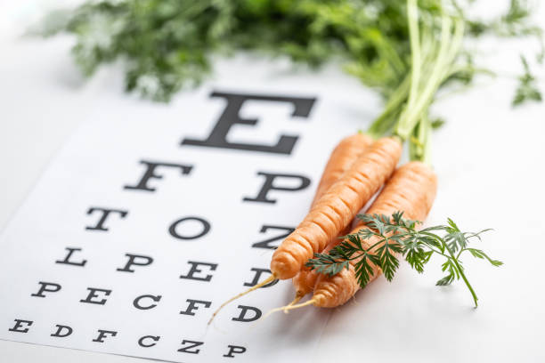 istock Fresh carrots as a source of vitamin A placed on the eye test chart. 1987695114