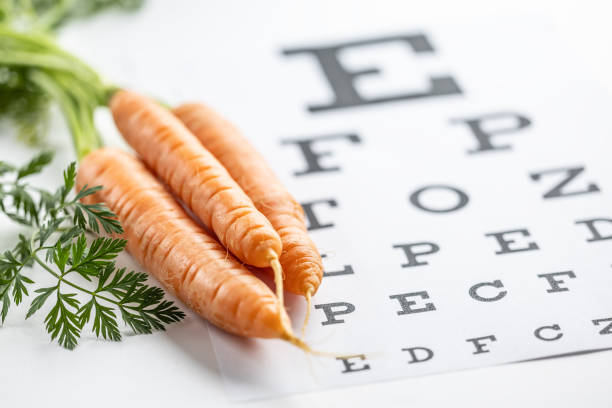 istock Fresh carrots as a source of vitamin A placed on the eye test chart. 1987695117