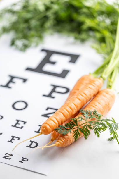 istock Fresh carrots as a source of vitamin A placed on the eye test chart. 1987695674