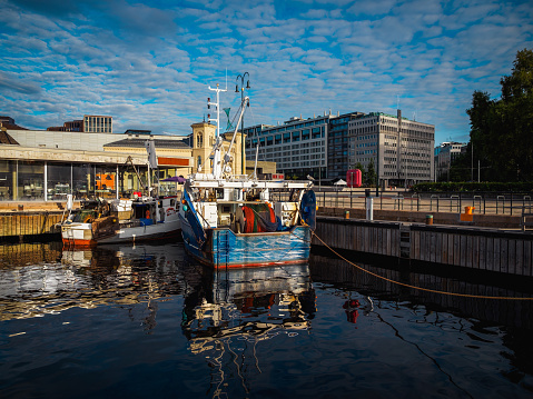 two shrimp boats moored on a pier on a city wharf in the morning