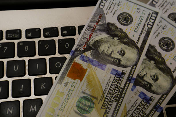several hundred dollar bills on the laptop keyboard
