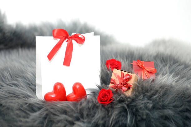 Festive background from gift bag with bow, hearts,gift boxes on gray fur for valentine's day, mother's day, birthday