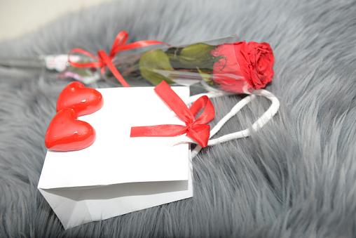 Festive background from gift bag with bow, hearts,gift boxes on gray fur for valentine's day, mother's day, birthday