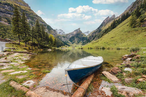 Beautiful view of Seealpsee mountain lake and boat in Alpstein mountain range on summer at Appenzell, Switzerland