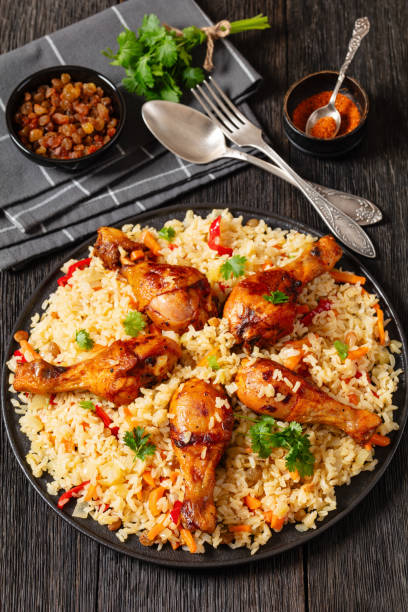 istock fried chicken drumsticks over rice pilaf, top view 1987743855