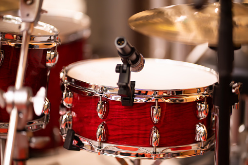 Complete set of musical instruments with complete set of red drums in studio music concept.