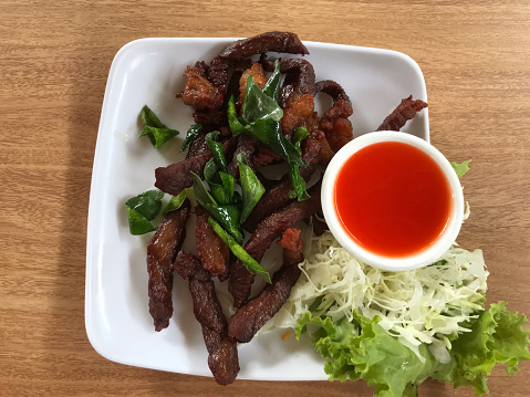 Fried pork with chili sauce on white plate, Thai food.