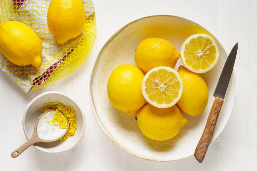 Group of edible lemons on wooden white table.