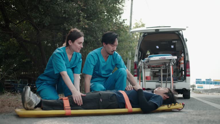 Nurse team preparing and tie a mobile emergency bed from an emergency vehicle