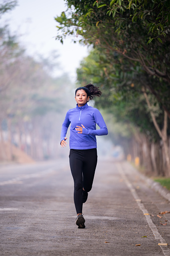 Running woman. Female runner jogging during outdoor on road