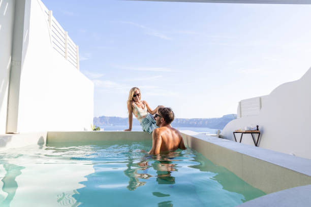 istock Greek Getaway: Young Couple Relaxing by Private Villa Pool with Sea View 1987768297