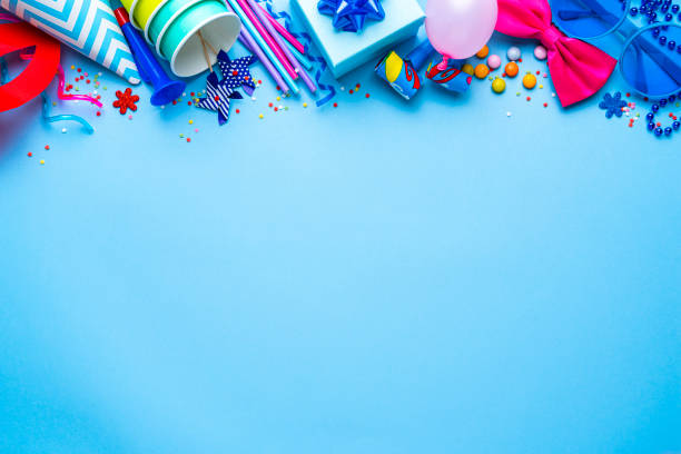 istock Birthday party or carnival accesories border on blue background. Copy space 1987781339