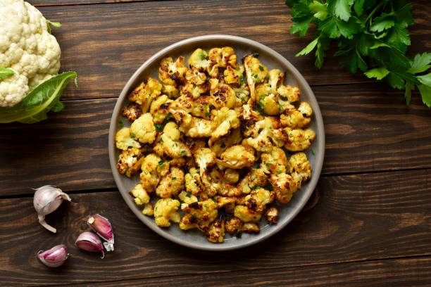 istock Roasted cauliflower on plate over wooden background 1987787175