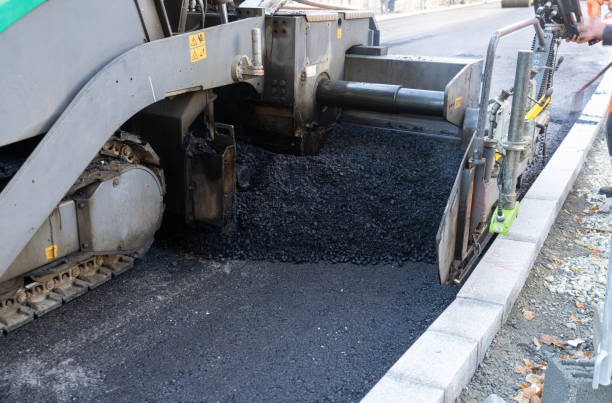 Industrial pavement machine laying fresh asphalt