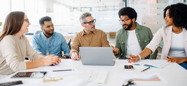istock A lively discussion unfolds among four colleagues around a table 1987788756