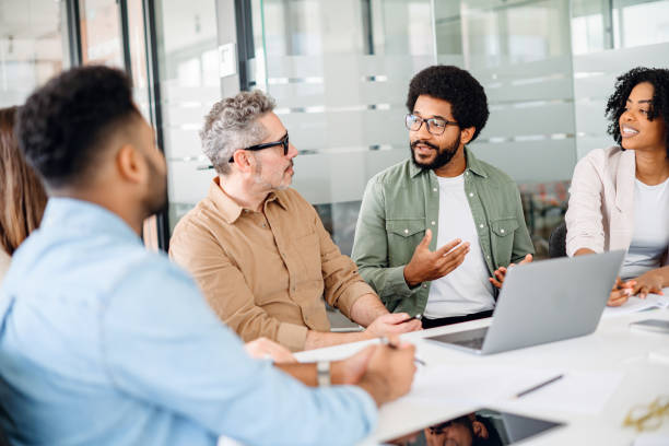 istock Colleagues engage in a lively exchange of ideas in an office 1987788764
