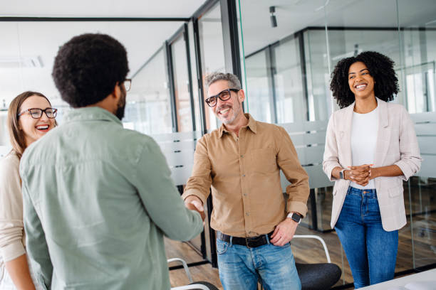 istock A friendly office environment is depicted where a team greets each other, shaking hands 1987788781