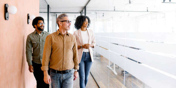 Three colleagues walk through their office space, engaged in a casual conversation