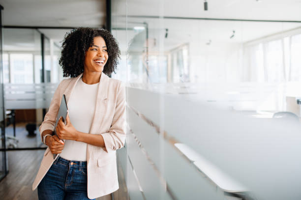 A young professional woman stands confidently in a modern office
