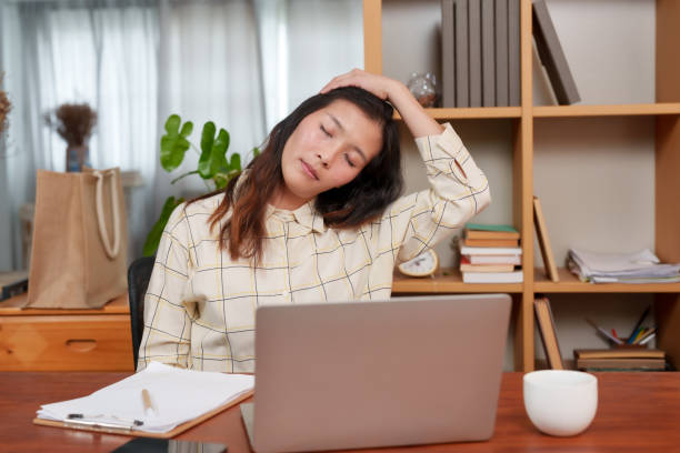 istock Overwork and fatigue shown by an Asian worker, resting her eyes in a home office environment. moment of exhaustion for an Asian professional, indicating the need for a break from computer work 1987793056