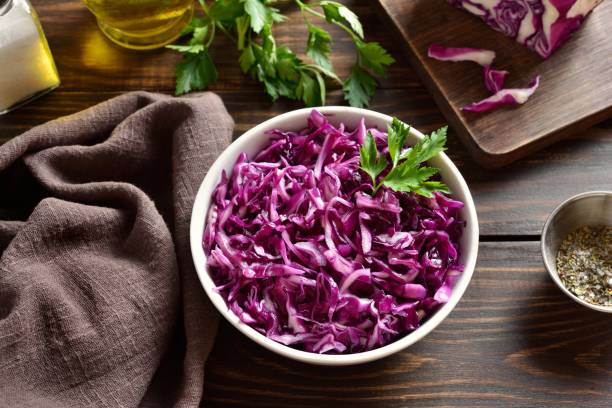 istock Raw red cabbage in bowl on wooden table 1987794118