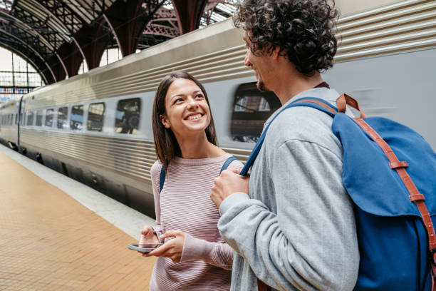 istock Young Couple Using A Phone While Waiting For A Train At The Railway Station In Copenhagen In Denmark 1987796294