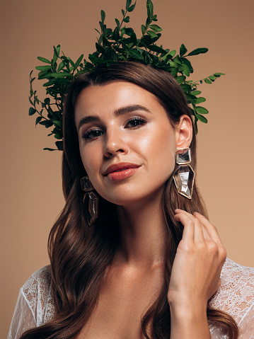 Young beautiful girl with wreath of leaves on the head