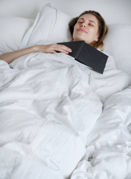 istock A young beautiful girl fell asleep reading a book before sleeping 1987820160