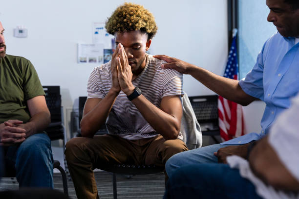 istock Young male soldier consoled by fellow veteran during support group 1987823948