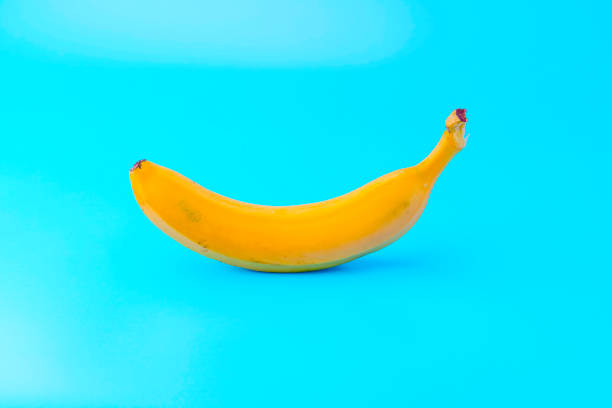 istock Ripe yellow banana on blue background 1987828203