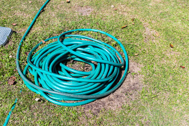 istock Garden hose on green grass 1987850155