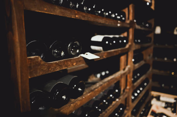 wine bottles in cellar. - dust old cabernet sauvignon grape aging process photos et images de collection