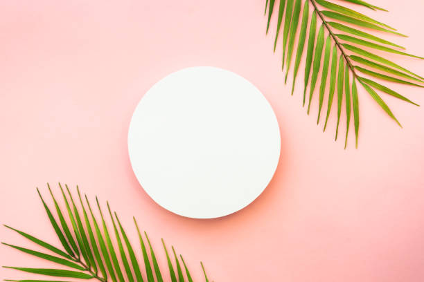istock Palm leaves and white podium on pink background. 1987865478