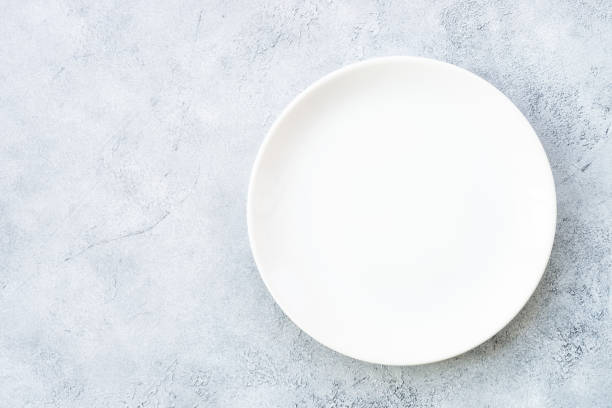 istock White plate and napkin at stone table. 1987872272