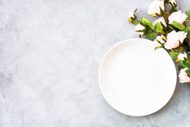 istock Table setting with white plate, cutlery and flowers. 1987872810