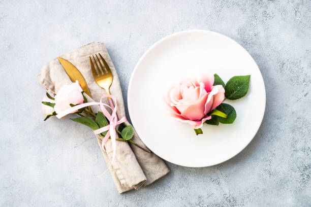istock Table setting with white plate, cutlery and flowers. 1987873337