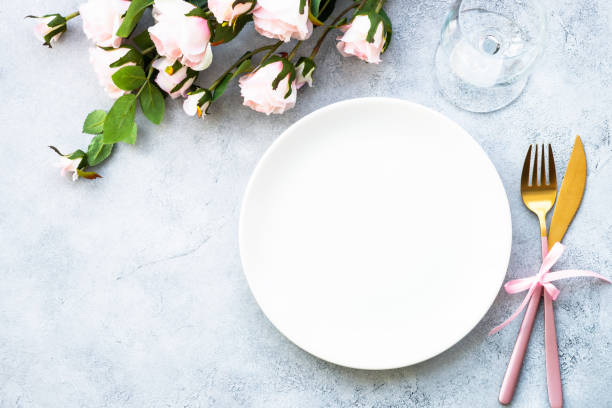 istock Table setting with white plate, cutlery and flowers. 1987873348